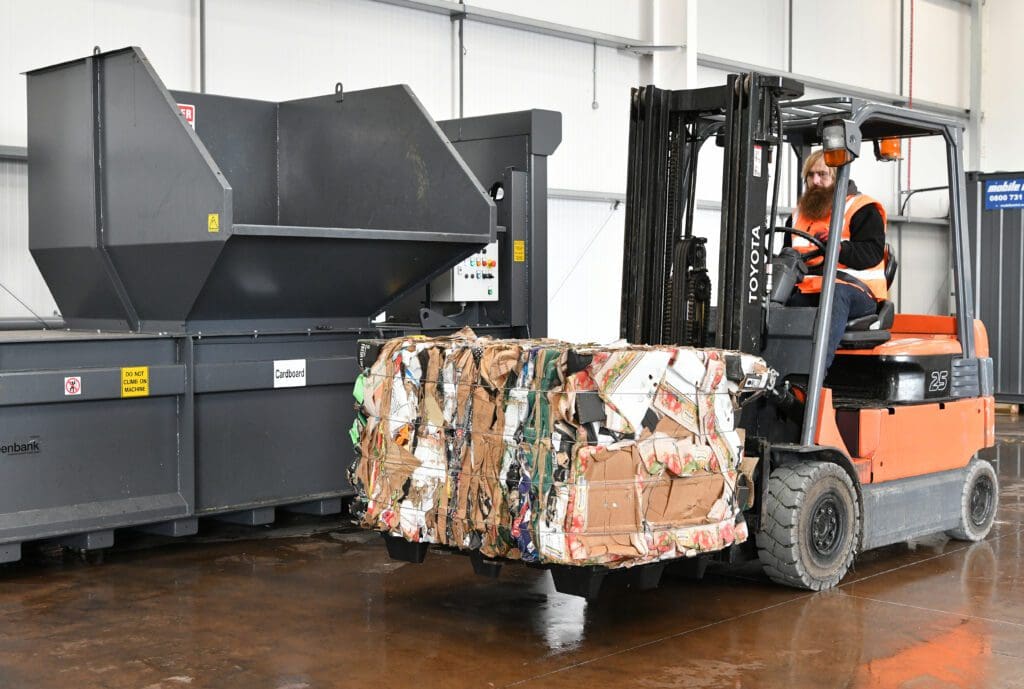 Axil Team member moving cardboard baler