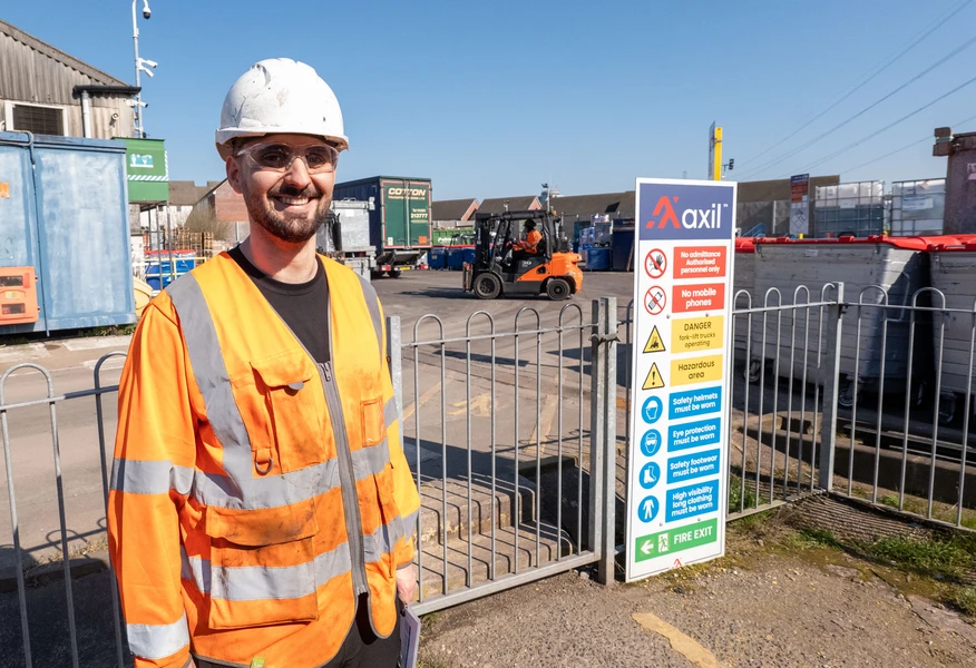 On-site chemist wearing PPE at an Axil waste management facility, supporting hazardous waste handling, compliance and environmental services.