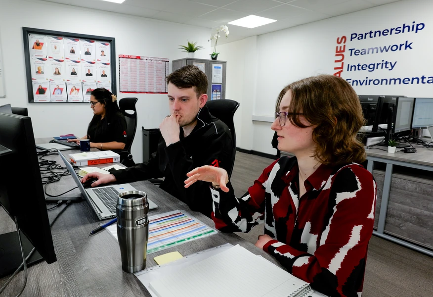 Team reviewing waste management and sustainability performance data in an office environment, analysing operational insights to identify improvement opportunities.