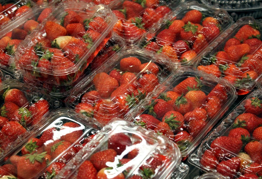 Fresh strawberries packaged in plastic containers for food production and distribution